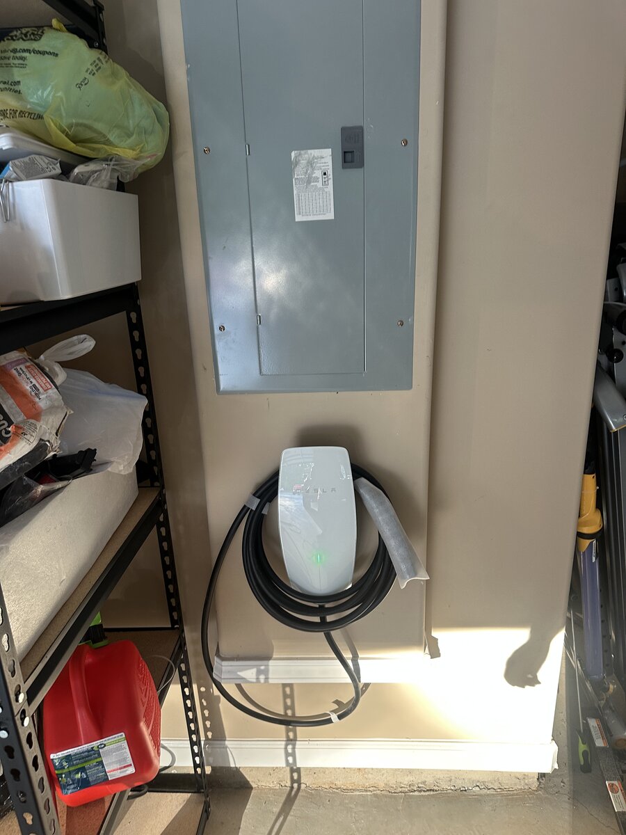 Tesla home charging setup with wall-mounted cable organizer