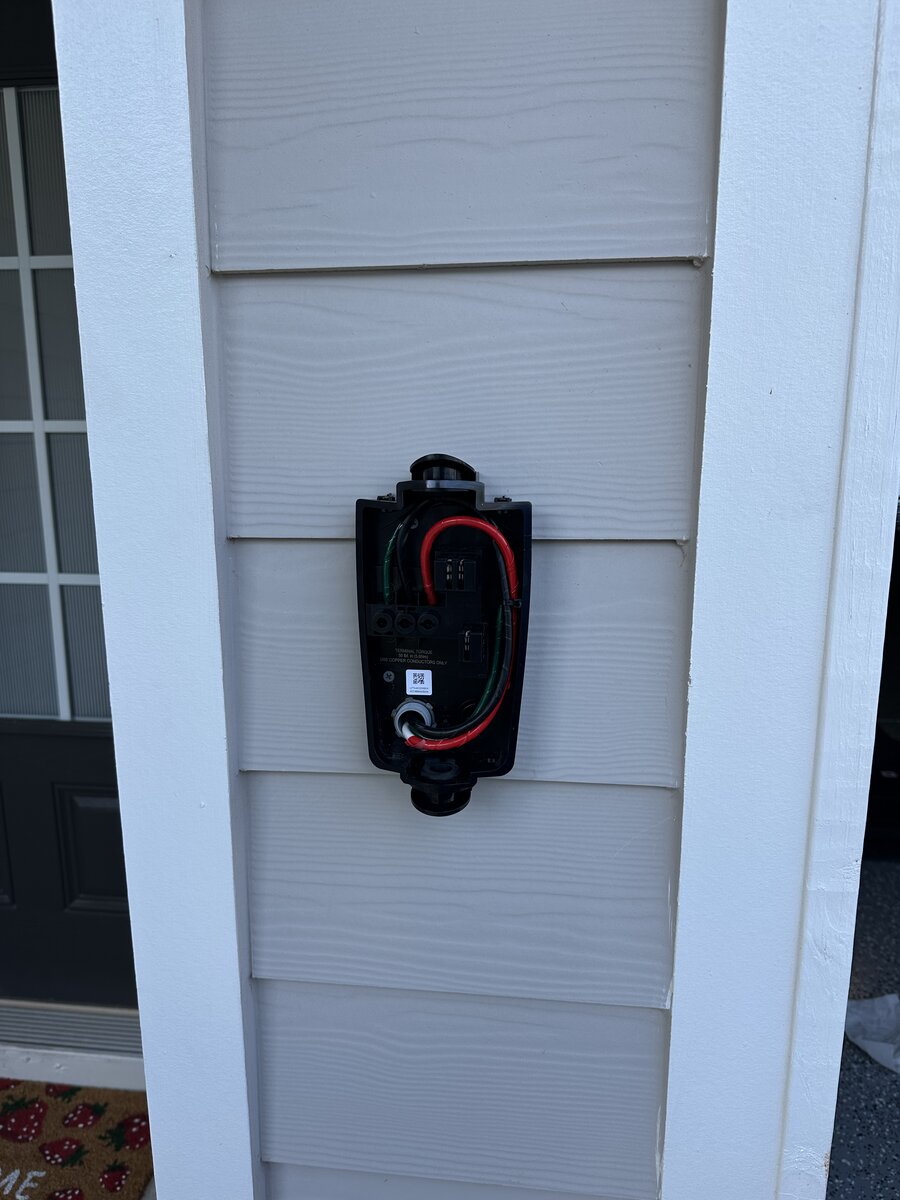 Tesla Wall Connector installed on residential siding